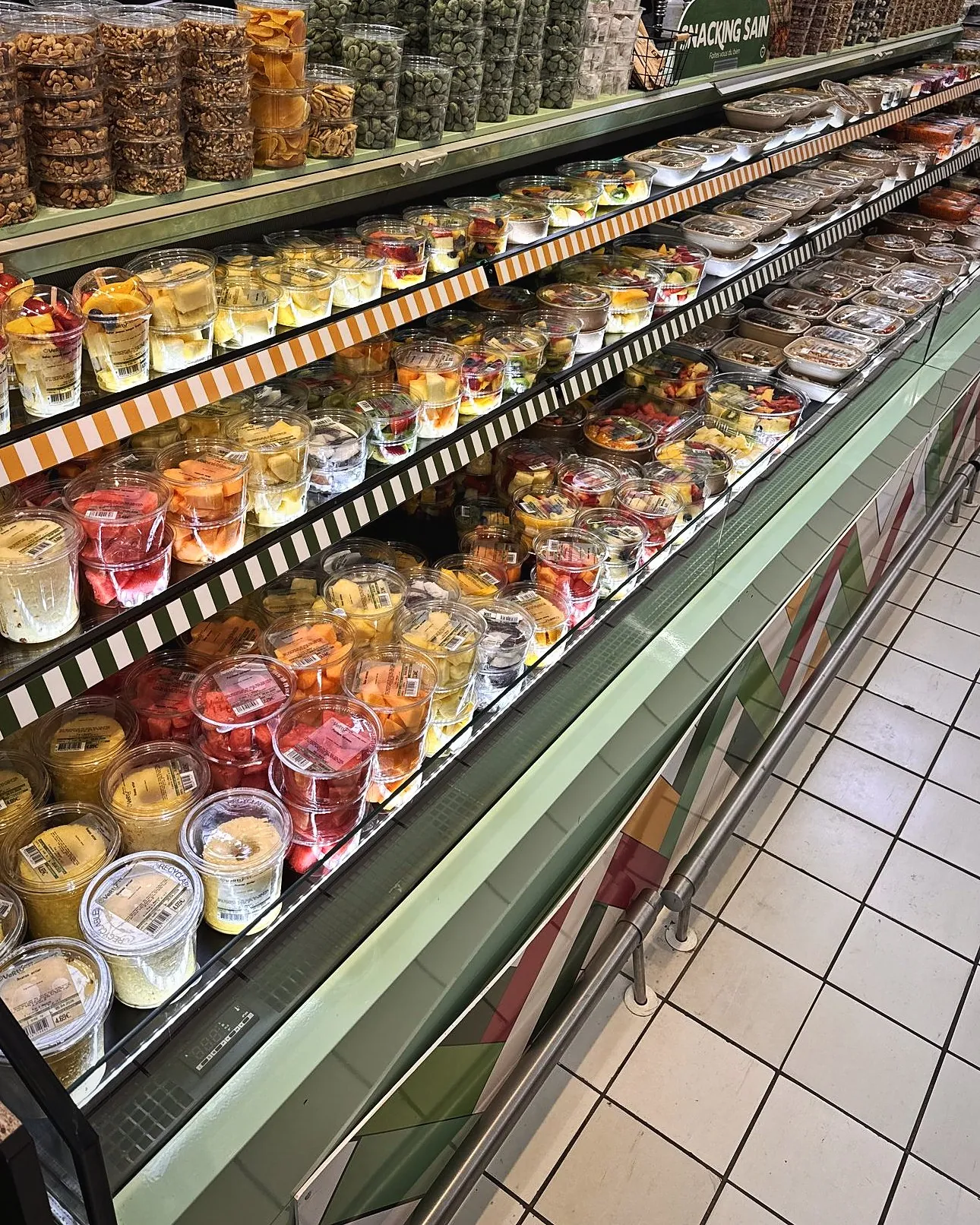 Vitrine Vertu Food garnie de pots de fruits, olives et fruits secs