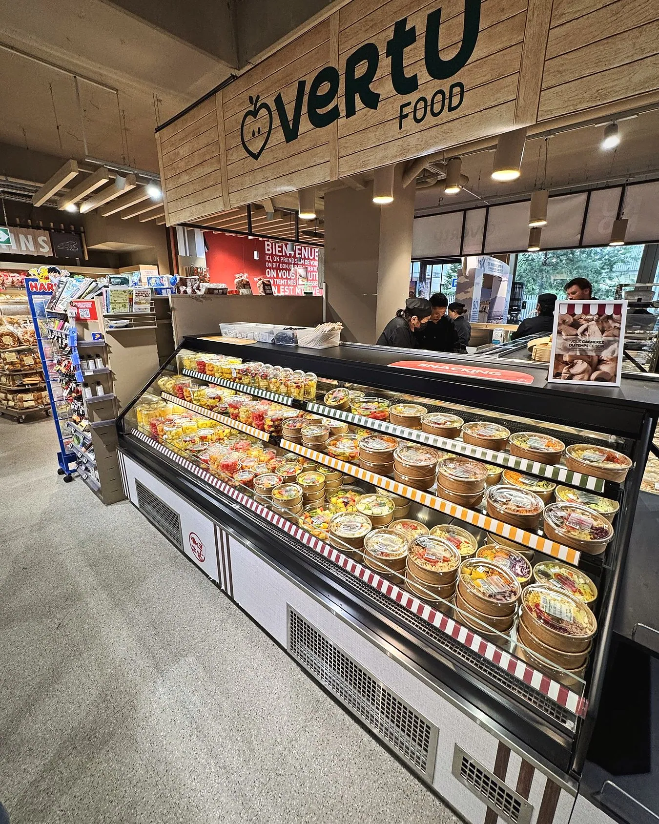 Kiosque Vertu Food à l'enseigne en bois, vitrine de salades et fruits frais